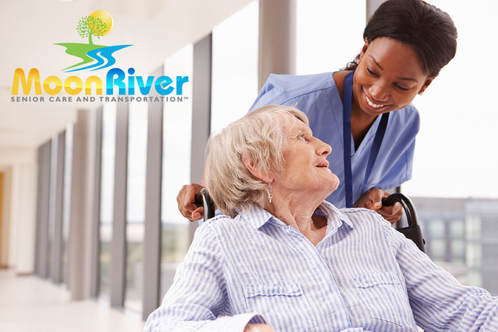 Nurse Pushing Senior Patient In Wheelchair - Moon River Senior Care