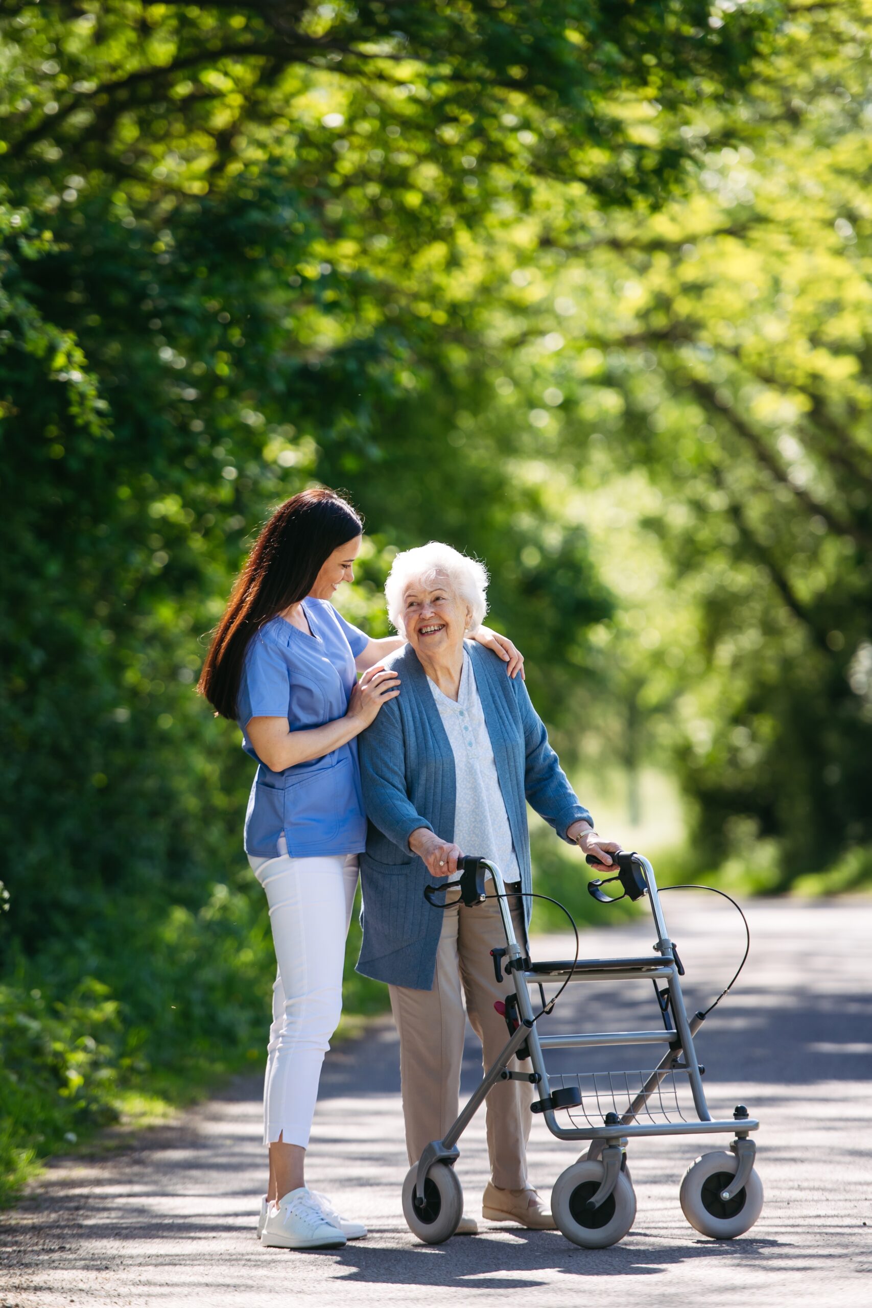 Female,Caregiver,And,Senior,Woman,With,Walker,On,Walk,In